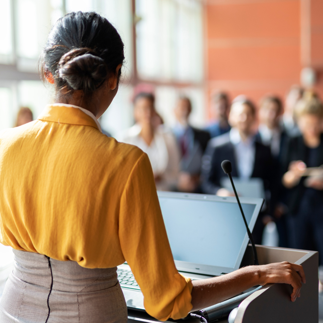 A photo of a woman who speaks in front of audience